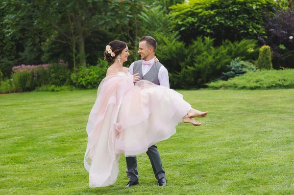 Holding a gyönyörű menyasszony az ő karjai vőlegény — Stock Fotó