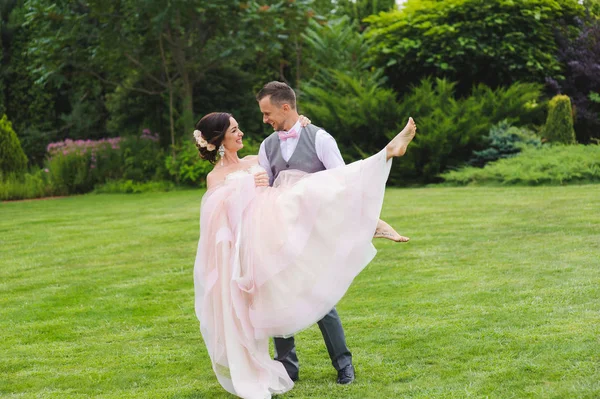Holding a gyönyörű menyasszony az ő karjai vőlegény — Stock Fotó