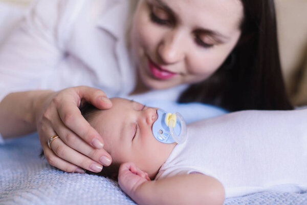 Mom gently stroking the babys head