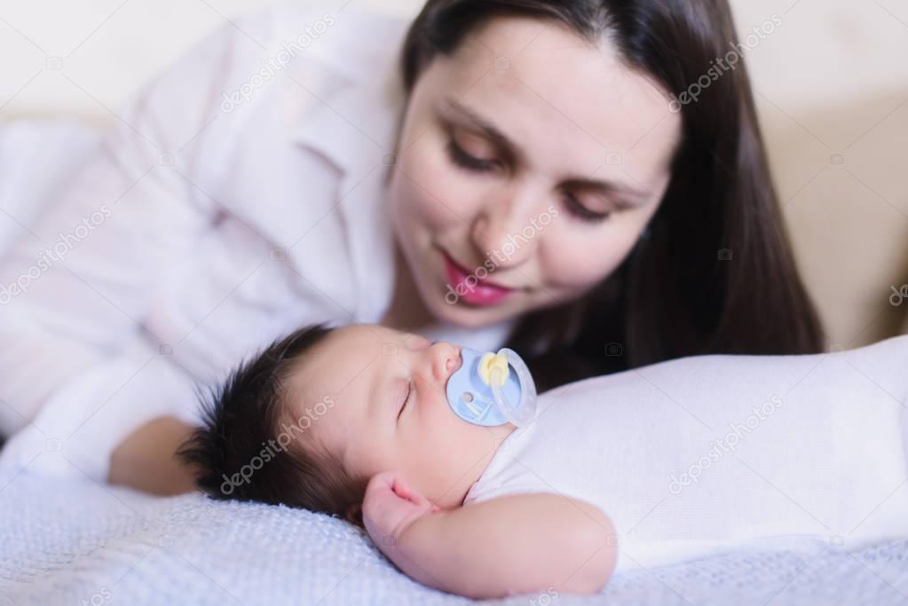 Happy young mother near sleeping baby. close-up