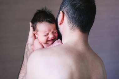 Babası omzunda ağlayan erkek bebek