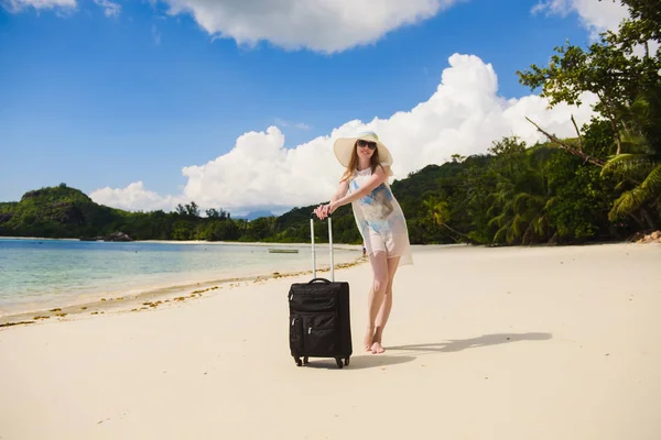 Meisje met een koffer op het strand — Stockfoto