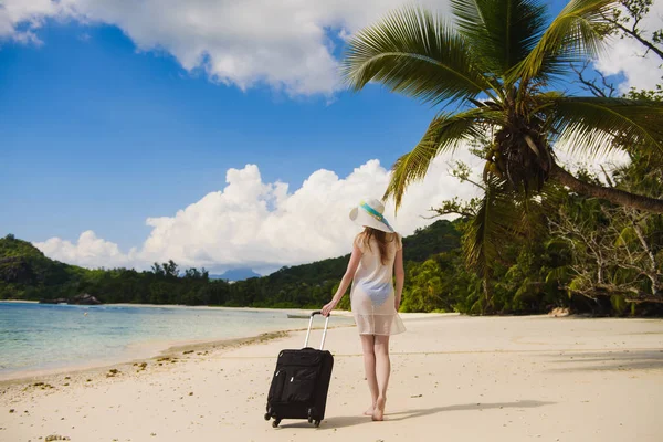 Meisje met een koffer op het strand — Stockfoto