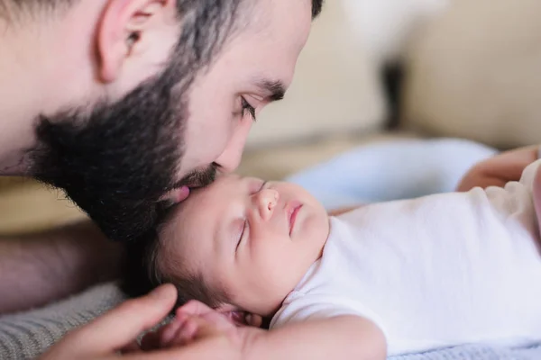 Junger Vater küsst sein Neugeborenes — Stockfoto