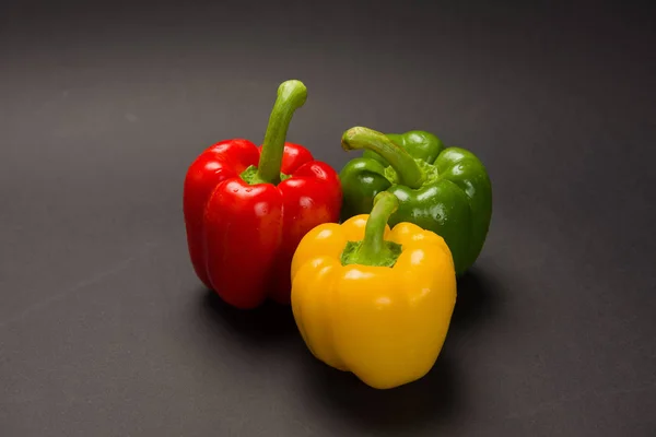 Drei Paprika auf schwarzem Hintergrund — Stockfoto