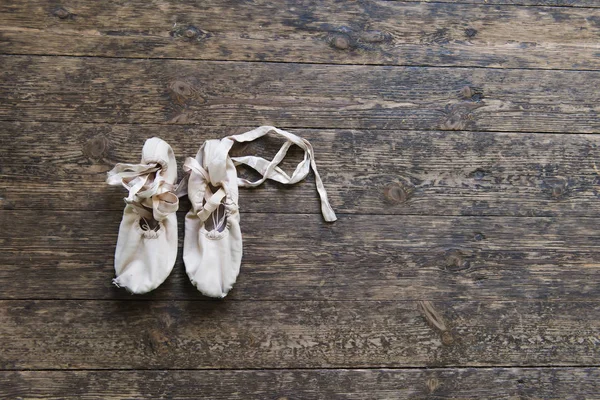 Old ballet shoes on old wooden floor. — Stock Photo, Image