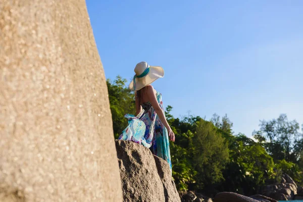 Mulheres está de pé sobre uma rocha na praia — Fotografia de Stock