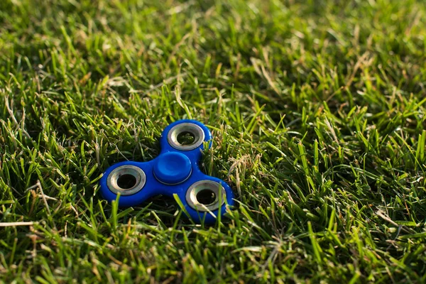 Tri Fidget Hand Spinner na grama — Fotografia de Stock