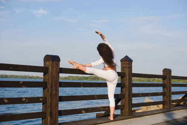 Femeie însărcinată care face yoga lângă râu — Fotografie, imagine de stoc