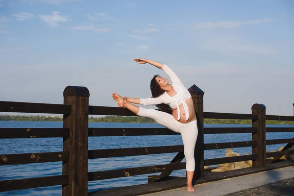 Femeie însărcinată care face yoga lângă râu — Fotografie, imagine de stoc