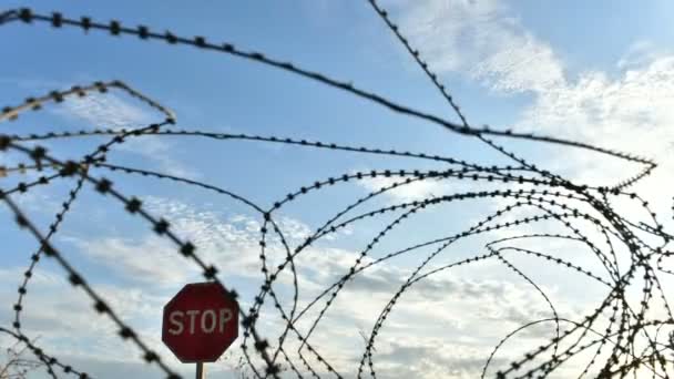 Clouds sail over fence with barbed wire. — Stock Video