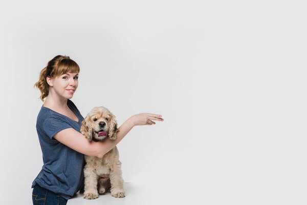 Woman with dog pointing to space at right