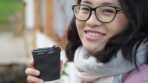 Азиатка пьет кофе и смеется. — стоковое видео