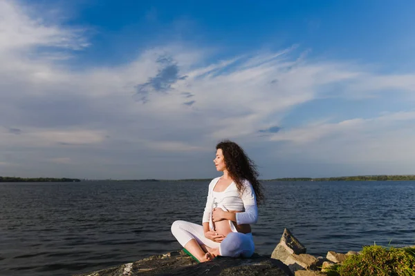 Meditând femeia gravidă în poziția de lotus . — Fotografie, imagine de stoc