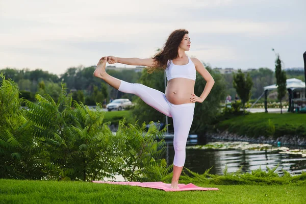Femeia gravidă care face yoga prenatală pe natură . — Fotografie, imagine de stoc
