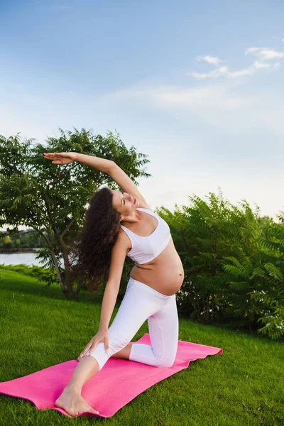 Femeia gravidă care face yoga prenatală pe natură . — Fotografie, imagine de stoc