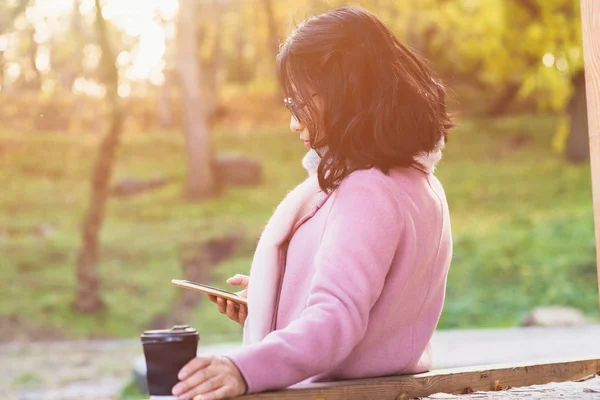 Jonge Aziatische vrouw met warme dranken buiten — Stockfoto