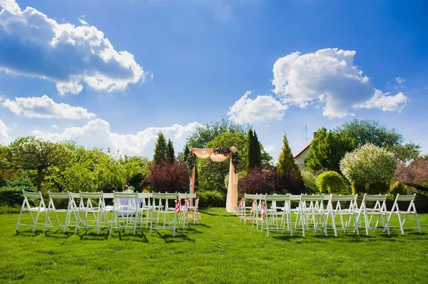 Arco de boda y sillas blancas sobre fondo natural — Foto de Stock