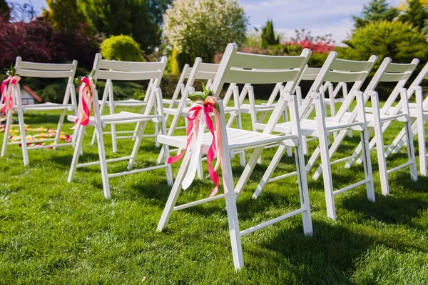 White chairs with pink and peach colors ribbons — Stock Photo, Image