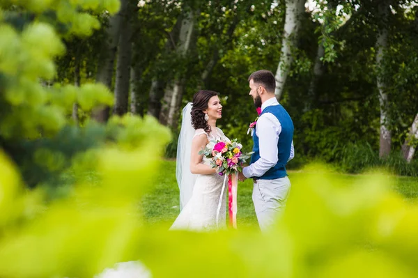 Csak marriend a fiatal pár, szerelem, mosolygós természet zöld háttér — Stock Fotó