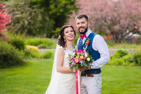 Menyasszony és a vőlegény, gyönyörű kert pózol — Stock Fotó