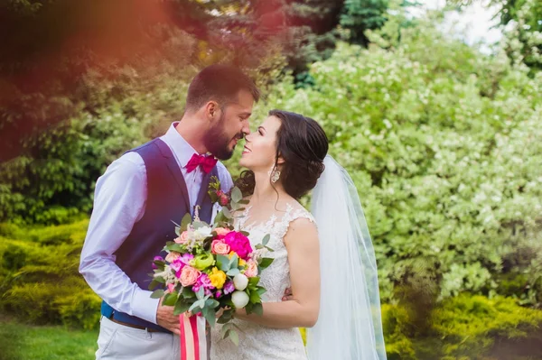 Feliz apenas casado casal beijando no jardim verde — Fotografia de Stock