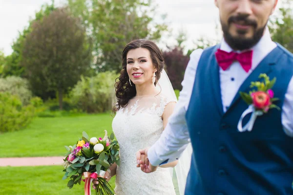 Наречений тримає руку своєї усміхненої щасливої нареченої — стокове фото