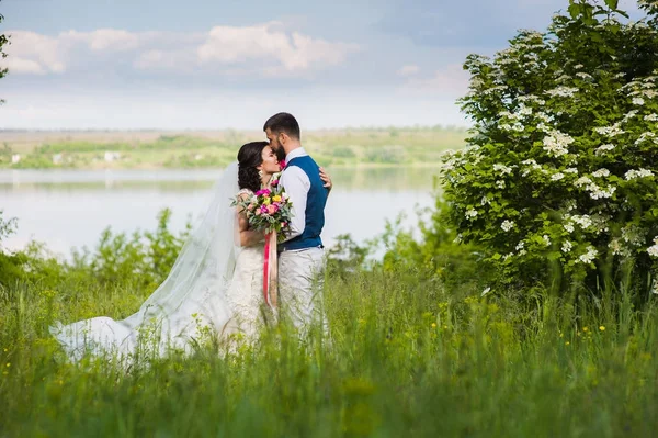 Frisch verheiratetes Paar im Landstrich mit Wasser — Stockfoto