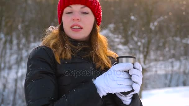 Flicka i röd hatt dricka te i skogen fryst — Stockvideo