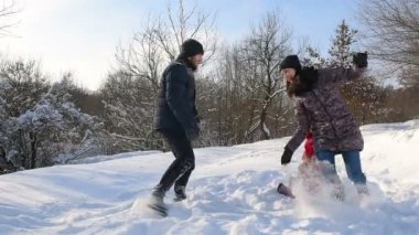 Mutlu aile eğleniyor karlı Park'ta karda oynarken.