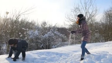 Çift kartopu karlı Parkı'nda mücadele. Mutlu aile eğleniyor karda oynarken.