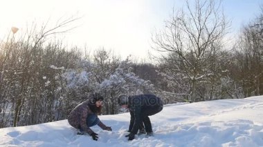 Genç çift açık havada olan karlı Park'ta karda oynarken eğlenceli. Kış eğlence. Kar fırlatma.