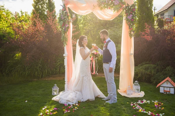 Noiva e noivo fazendo vivas com champanhe durante sua cerimônia de casamento — Fotografia de Stock