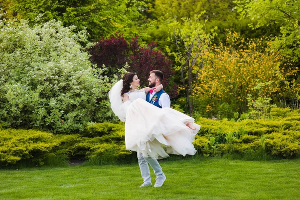 Novio sostener su novia en manos en verde fondo —  Fotos de Stock