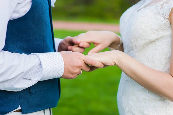 Närbild av brudgummen håller händerna på sin brud — Stockfoto