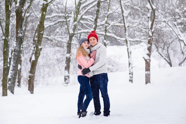 Ungt par i kramar i snö skog — Stockfoto