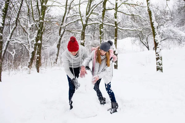Aktivt par tonåringar att göra snögubbe — Stockfoto