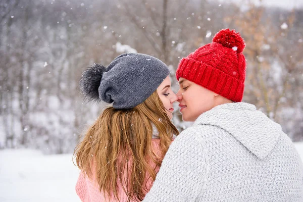 Casal feliz no fundo da neve de volta — Fotografia de Stock