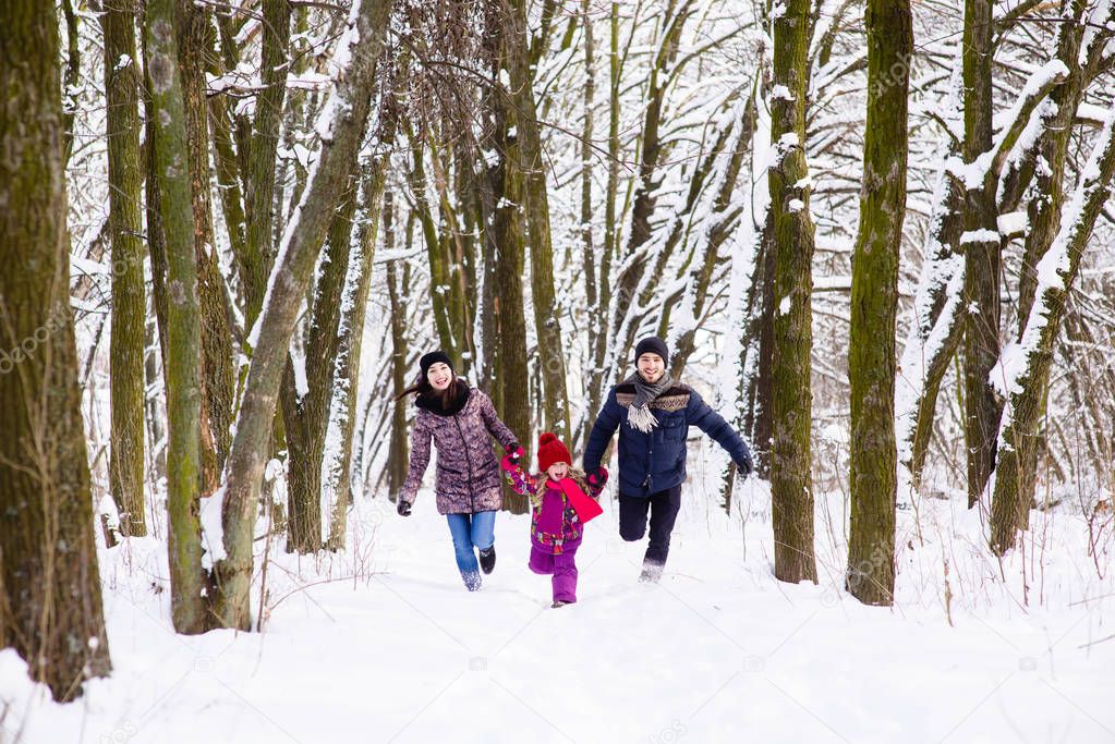 Happy family run in winter forest