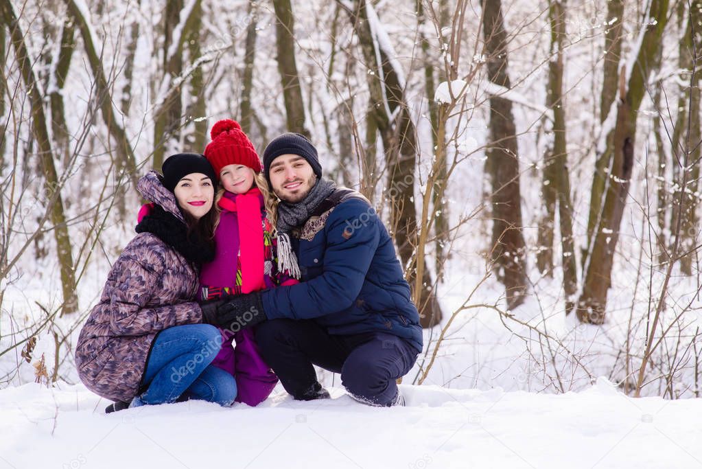 Happy young family posing in snow park