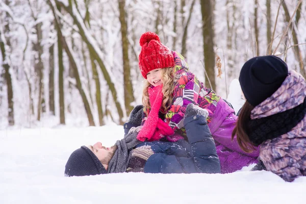 Happy family playing in winter forest