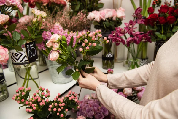 Kvinnliga händer i butik med blomma bakgrund — Stockfoto