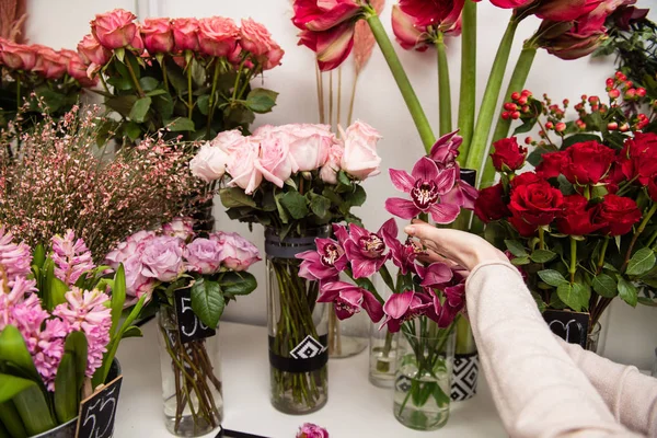 Kvinnliga händer i butik med blomma — Stockfoto