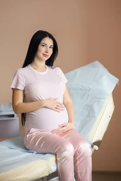 Frumoasa femeie însărcinată stă pe canapea în spital — Fotografie, imagine de stoc
