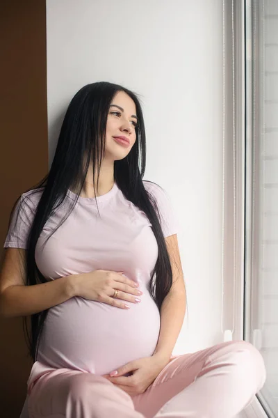 Portrait de femme enceinte souriante assise dans le rebord de la fenêtre — Photo