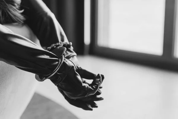 Frauenhände in Lederhandschuhen und Handschellen in Großaufnahme — Stockfoto