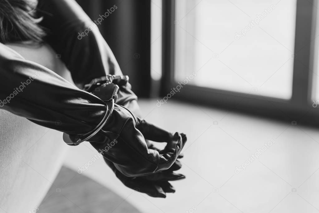 Female hands in leather gloves and handcuffs close-up