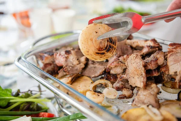 Zange fängt Stück gegrillte Zwiebel — Stockfoto