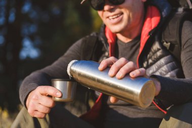Termosu erkek ellerindeki bardakla kapat