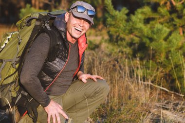 Yakışıklı son sınıf öğrencisi ormanda yürüyüş yapıyor.